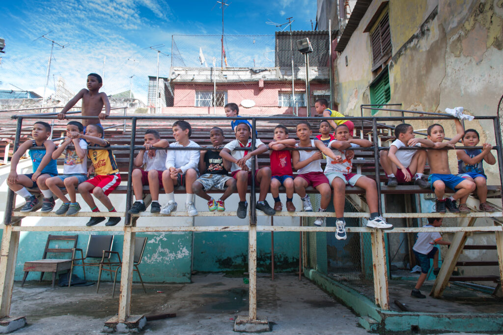 Kinder sitzen auf der Tribüne der Box Arena Gimnasio Rafael Trejo in Alt-Havanna und verfolgen aufmerksam das Geschehen in der Arena