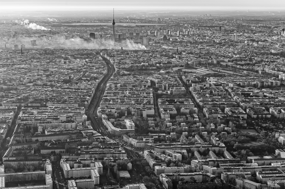Schwarz-Weiß-Luftaufnahme von Berlin mit Fernsehturm und geometrischer Blockstruktur der Stadt